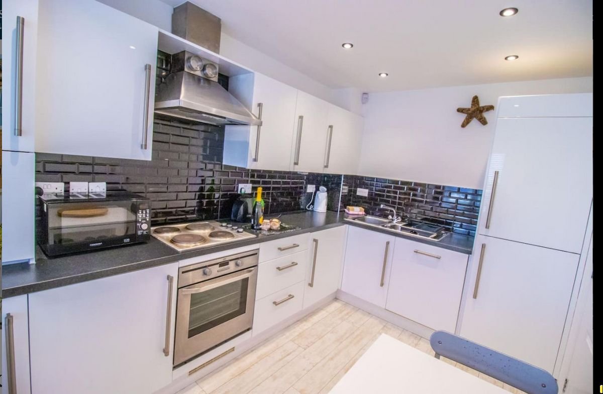 Fully equipped kitchen at Beachside Cottage with oven, hob and starfish decoration