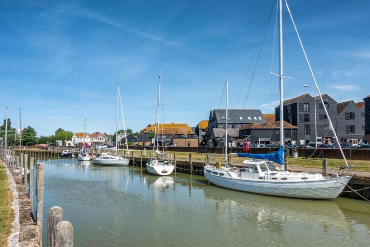 Sailing boats moored at Rye Harbour under a blue sky